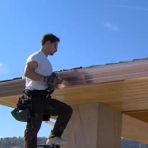 Worker installing new gutters