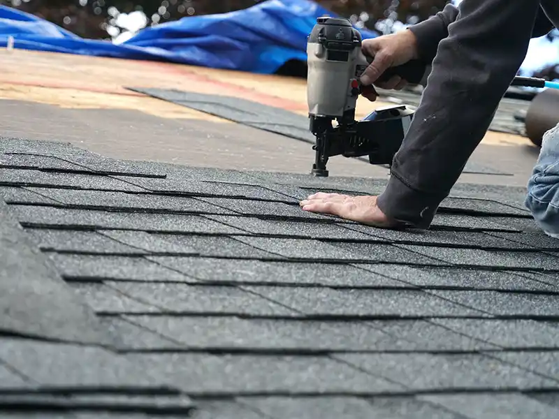 Worker installing new shingles